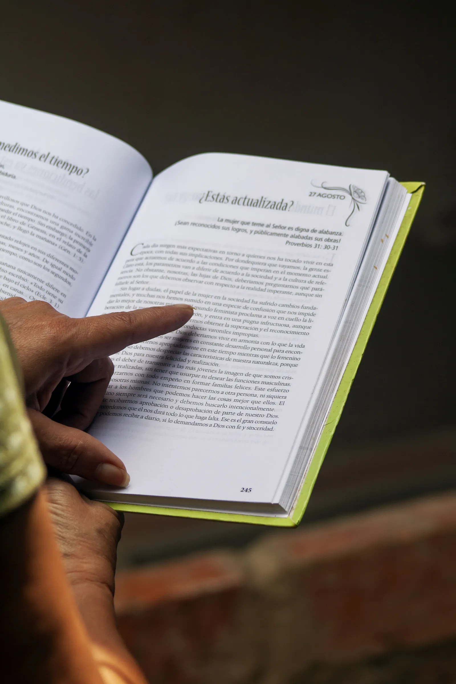 A person browsing an outdoor secondhand book and magazine stall.