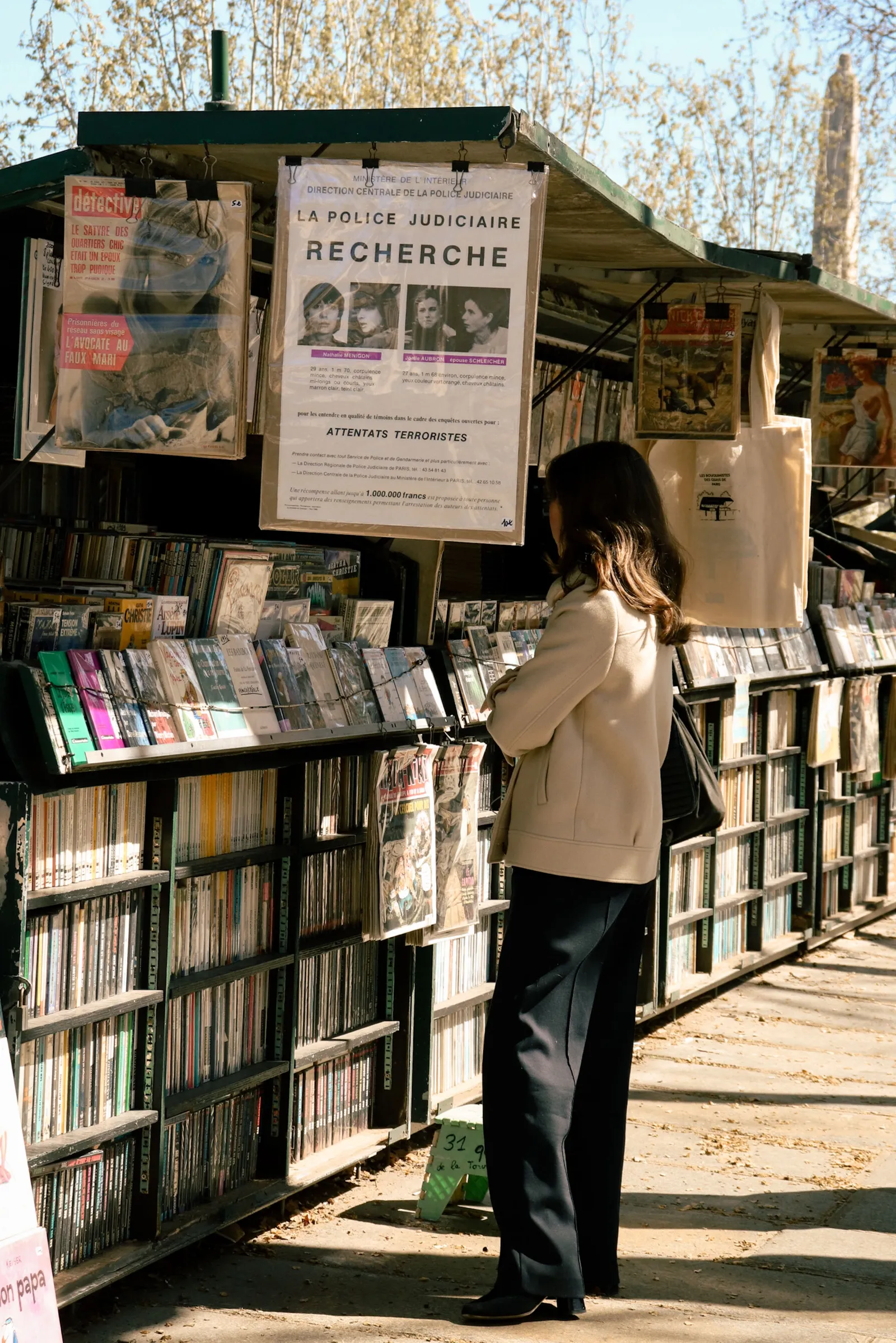 Un bouquiniste parisien en plein air avec de vieux livres et magazines français.