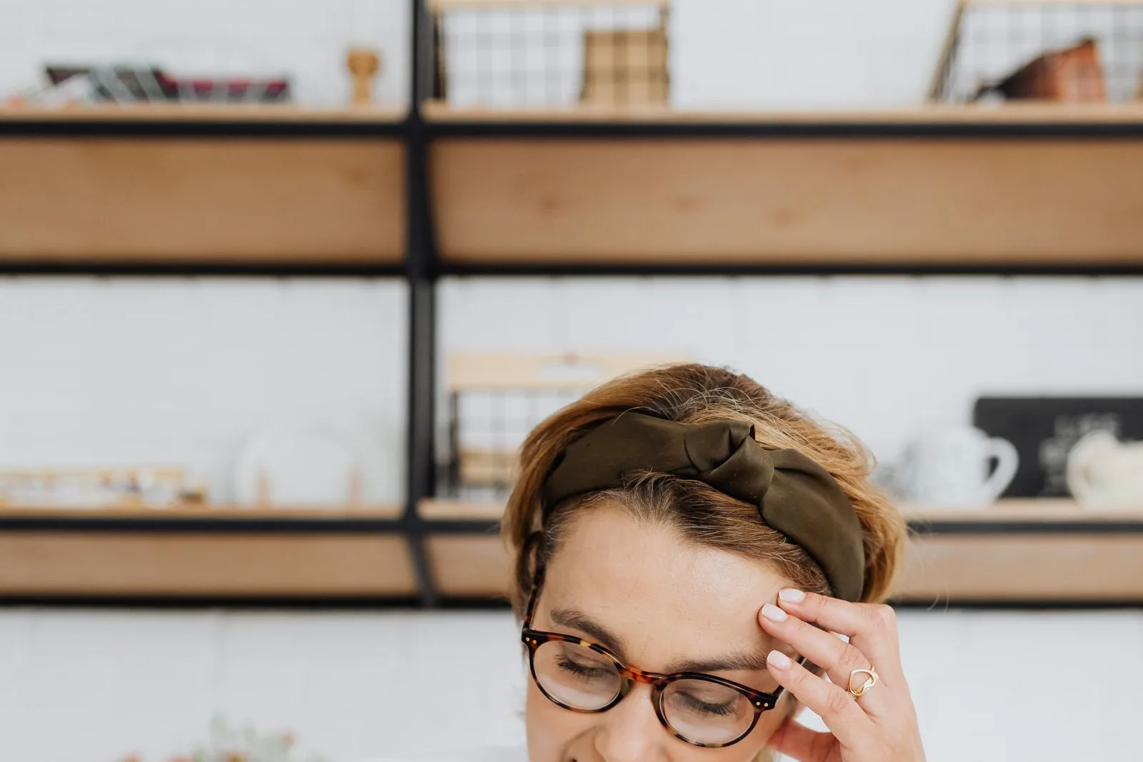 A pensive, frustrated woman facing an open book, symbolizing the reading plateau in language learning.