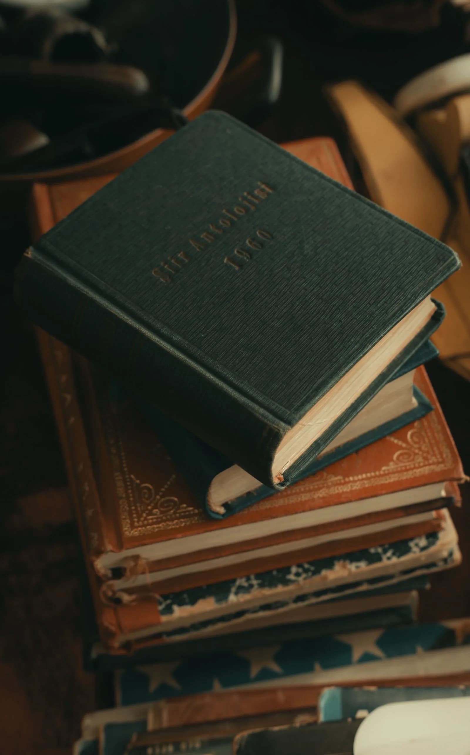 A pile of old books, some visibly worn, stacked together.