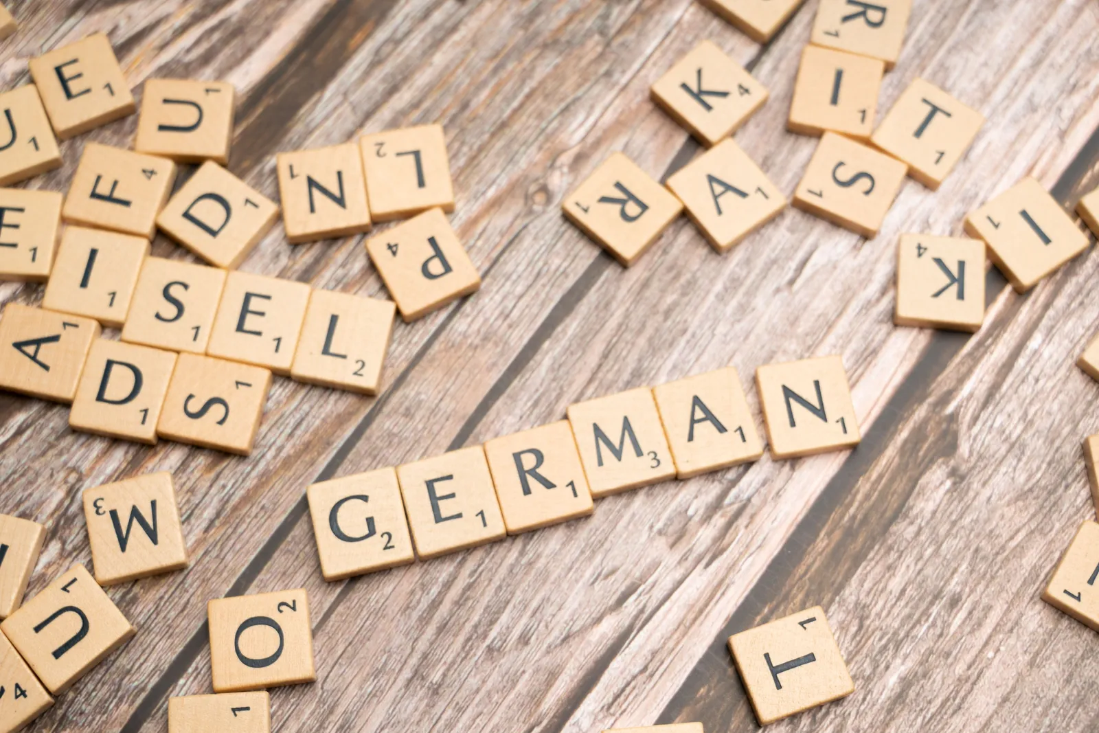 Wooden Scrabble tiles spelling GERMAN on a wooden table.