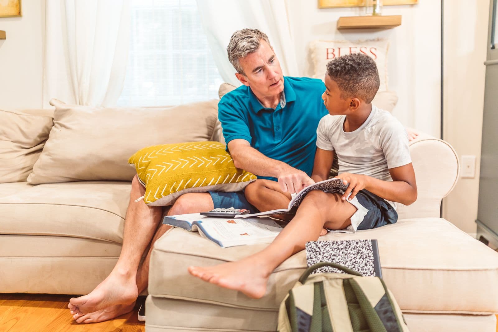 Père et fils lisant ensemble sur un canapé