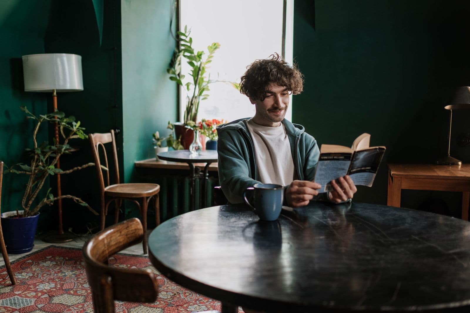 Person reading a book in a quiet coffee shop