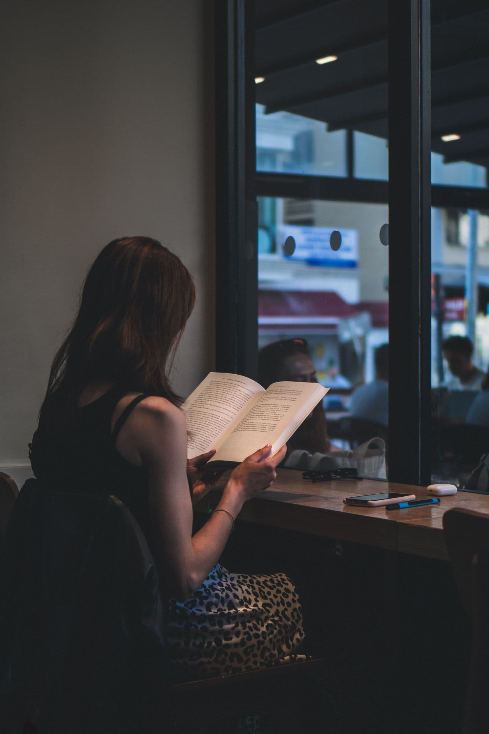 Person reading calmly by a window