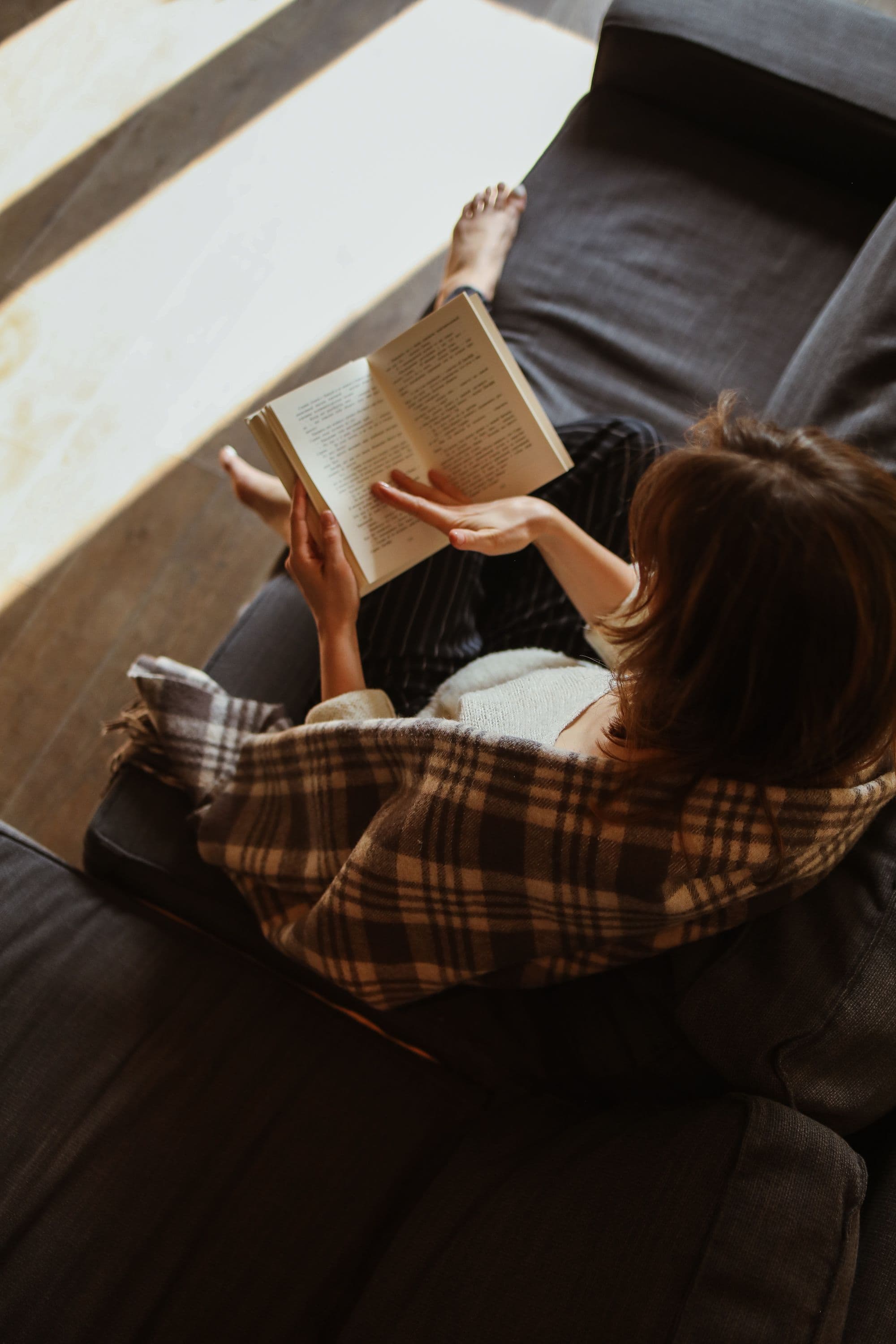 Woman reading on a sofa in natural light